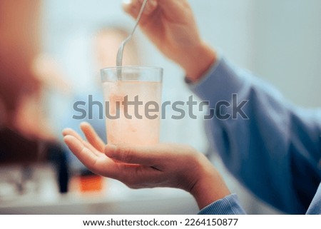 
Woman Mixing Powder Medicine in a Glass of Water. Person preparing a soluble drink with a nutritional supplement 
 Royalty-Free Stock Photo #2264150877