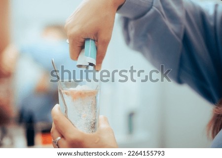 
Hand Poring a Powder Medicine into a glass of water. Person holding sachet dissolving collagen powder
