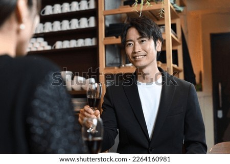 A couple of men and women drinking wine at a restaurant (mainly male) Royalty-Free Stock Photo #2264160981
