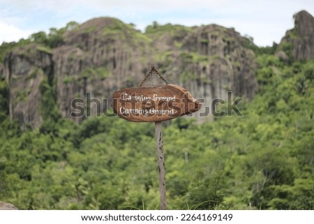 Camping ground signboard and ancient volcano background in Gunung Kidul, Indonesia