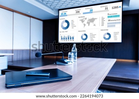Laptop on table with presentation on projector screen in meeting room