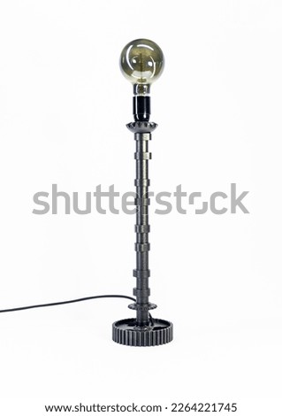 Black tall lamp with bulb on white background.