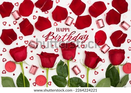Composition of red roses, chocolates, sequins hearts, candles, inscription Happy Birthday. Advertising celebrate content for Birthday. Flat lay, top view, close up, copy space on white background