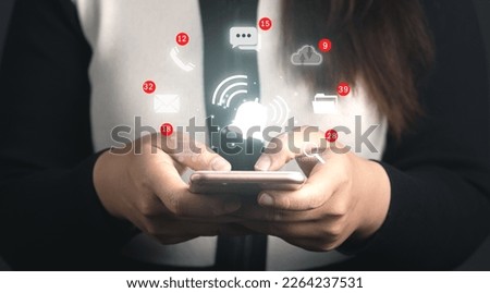Business people holding smartphone with virtual bell ringing and icons for application notification alert and social media icon include message,letter,cloud computing and call alert concept.