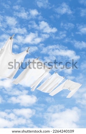 Different clothes drying on washing line against sky Royalty-Free Stock Photo #2264240109