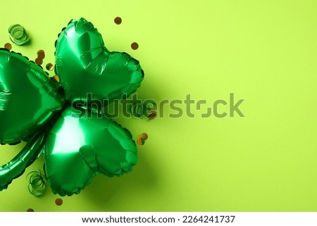 Shamrock shaped balloon with confetti on green background. Happy St Patrick Day greeting card template, banner design