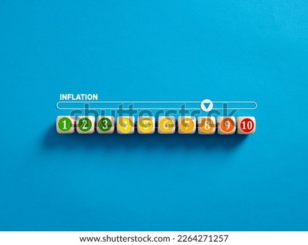 High inflation rate. Rising inflation level and economic recession. Measuring the inflation. Numbers on wooden cubes with a gauge meter bar on blue background. Royalty-Free Stock Photo #2264271257