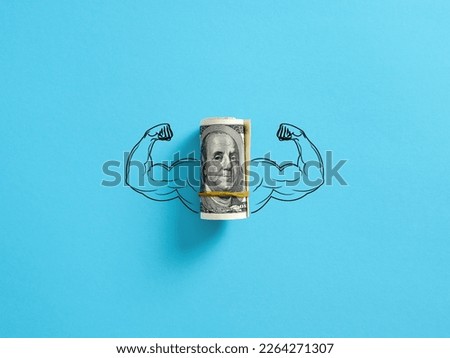 Bunch of United States dollar money with flexing muscle biceps on blue background. Strong or highest currency concept. Royalty-Free Stock Photo #2264271307