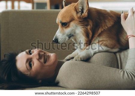 Owner female woman young girl playing with her dog welsh corgi pet . High quality photo