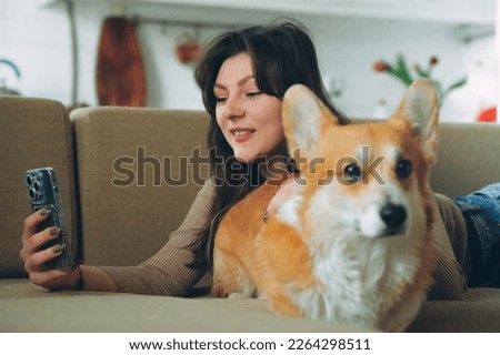 Owner female woman young girl taking selfie photo with her dog welsh corgi pet . High quality photo