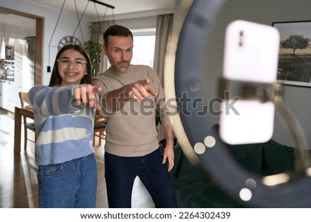 Teenager girl recording how dancing with dad at home
