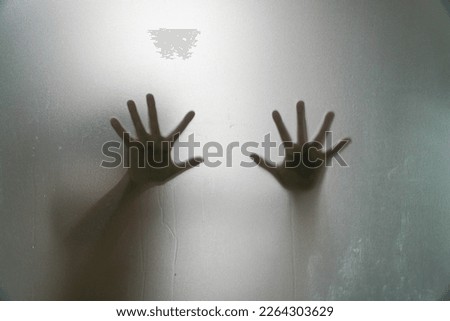 Left and right hand shadow blur behind frosted glass.shadow of hands behind frosted glass

