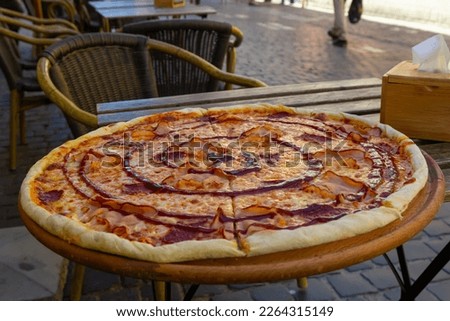 pizza on a wooden table of a street cafe on a summer day.