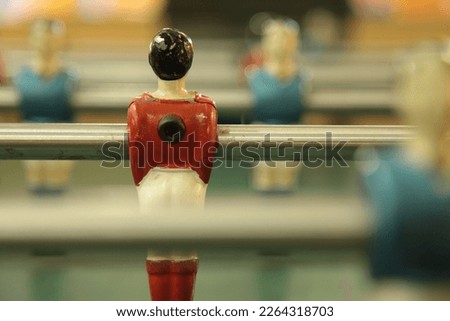 Table football, commonly called fuzboll or foosball (as in the German Fußball "football") and sometimes table soccer, is a table-top game that is loosely based on association football. Royalty-Free Stock Photo #2264318703