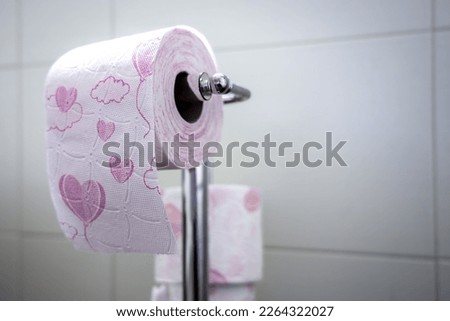 Toilet paper with hearts printed on the toilet paper holder