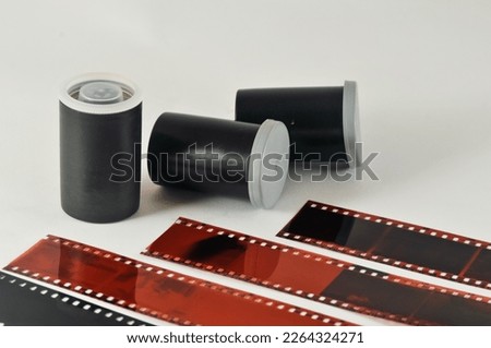35 mm negatives and rolls of film and their housings isolated on a white background.