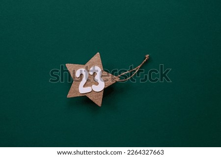 Greeting card for the Defender of the Fatherland Day. A gold star and the number 23 on a green background. The holiday is February 23.