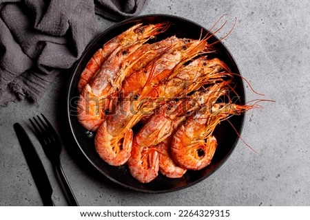 Top view of giant argentinian red prawns, grilled. Black plate. Dark grey background. Royalty-Free Stock Photo #2264329315