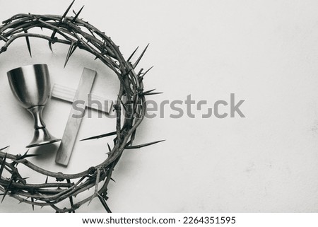 Crown of thorns, wine cup and cross on white background