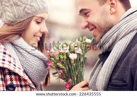 A picture of a man giving flowers to his lover on a winter day Royalty-Free Stock Photo #226435555