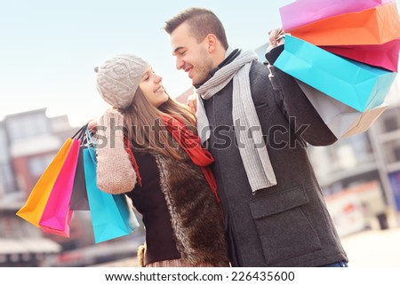 A picture of cheerful young people with shopping bags in the city