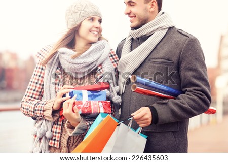 A picture of cheerful young people doing Christmas shopping