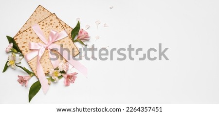 Jewish flatbread matza for Passover and flowers on light background with space for text Royalty-Free Stock Photo #2264357451