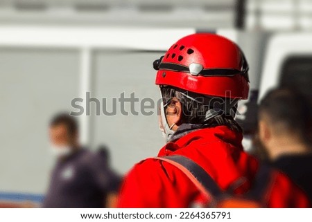 Unknown back of a search and rescue worker in front of blurred building