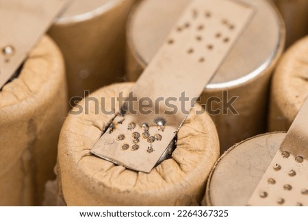Extreme Closeup of Bundle of Soldered Ni-Mh Rechargeable Batteries  Placed Together Over Beige Background. Horizontal Composition Royalty-Free Stock Photo #2264367325