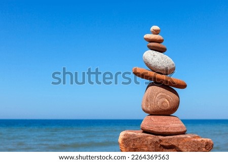 Rock zen pyramid of stones of different shapes on the beach. Concept of Life balance, harmony and meditation Royalty-Free Stock Photo #2264369563
