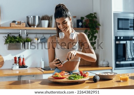 Shot of fintess woman making a healthy poke bowl in the kitchen at home.