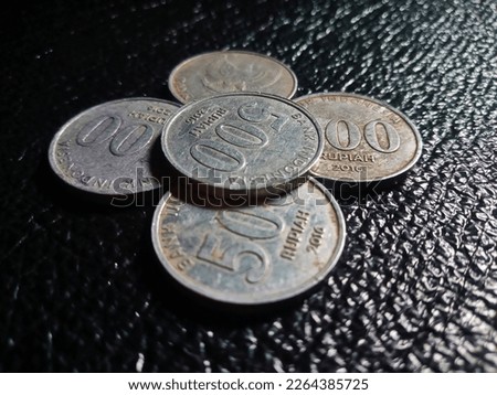 Close Up of 500 Rupiah Change Coins, An Indonesian Currency, on A Black Wrinkled Surface