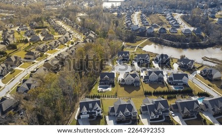 Master planned subdivision and urban sprawl with row of upscale houses new near large lake outside Atlanta, Georgia, USA. Aerial view new development suburban neighborhood multi stories homes