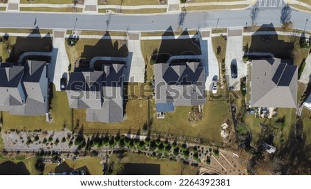 90 degrees vertical aerial view of shingle roofs on new development suburban houses with well-trimmed yards in upscale residential neighborhood near Atlanta, Georgia, USA. HOA homes in subdivision