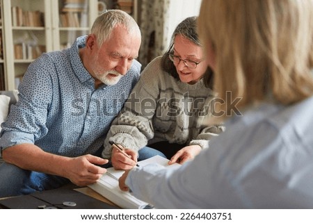 Senior couple signs a contract or power of attorney or fills out an application Royalty-Free Stock Photo #2264403751