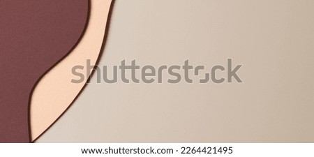 Beige colored paper texture background. Minimal paper cut style composition with layers of geometric shapes and lines in shades of brown colors. Top view