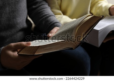 Couple sitting and reading holy Bibles, closeup Royalty-Free Stock Photo #2264424229