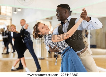 Woman with american man practising ballroom dancing Royalty-Free Stock Photo #2264433863