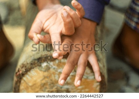 The human hand is on a tree and the background is blurred