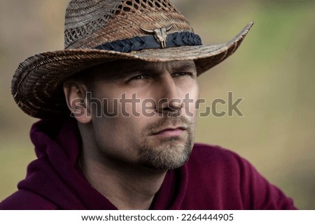 Portrait of a man wearing a hat and glasses. Cowboy in summer.
