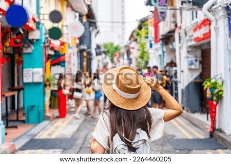 Young woman tourist with backpack walking at Haji Lane in Singapore