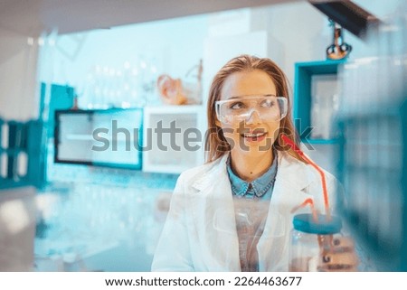 Young Scientist Working in The Laboratory. Scientist in lab doing research and using lab machines, test tubes, microscope and every laboratory equipment. Scientists in laboratory working on research
