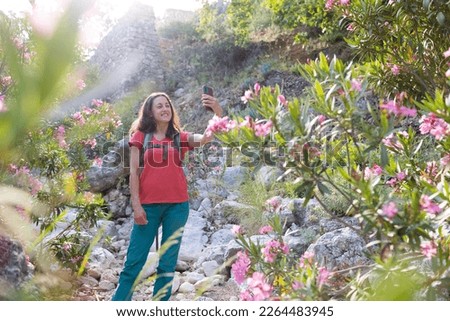 Traveling in Asia, a woman takes a selfie against the background of a landmark, a woman walks in a beautiful park with oleander flowers, ruins and landmarks