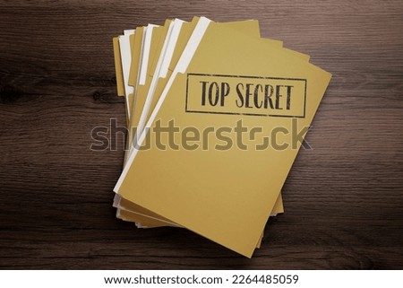 Yellow file with documents and Top Secret stamp on wooden table, top view Royalty-Free Stock Photo #2264485059