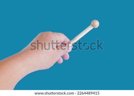 Hand holding a Woodenstick ,drumstick  on background.