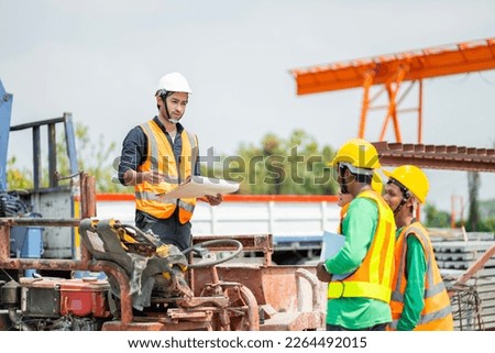 Male engineers are inspecting and controlling the work of the employees and the quality of the manufactured products to meet the standards In industrial factories producing precast prefabricated walls Royalty-Free Stock Photo #2264492015