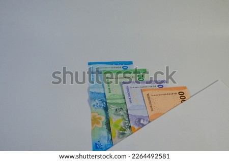 The new style of rupiah currency is arranged on a white background to form a unique shadow.