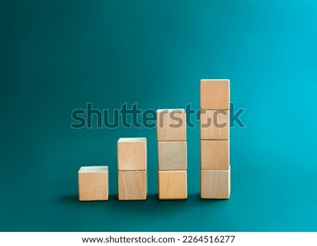 Blank wooden cube blocks bar graph chart steps, isolated on dark blue background, investment, income, trends, inflation, business growth, economic improvement concepts. Four step eco style wood graph.