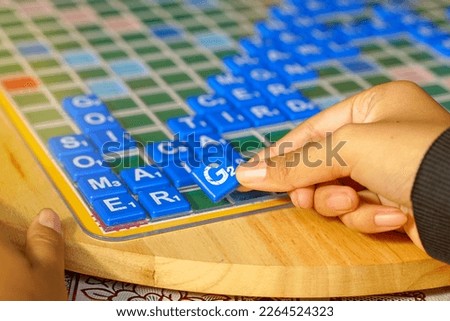 Asian high school students are competing in a Crossword or Scrabble game, an English word puzzle game. It is a game that promotes English learning and critical thinking skills.                        
