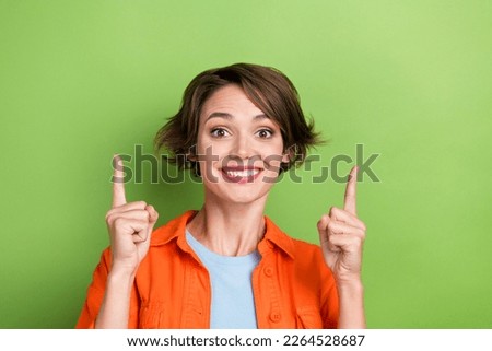 Photo of cheerful gorgeous lady wear orange trendy clothes arm presenting empty space spring discounts isolated on green color background